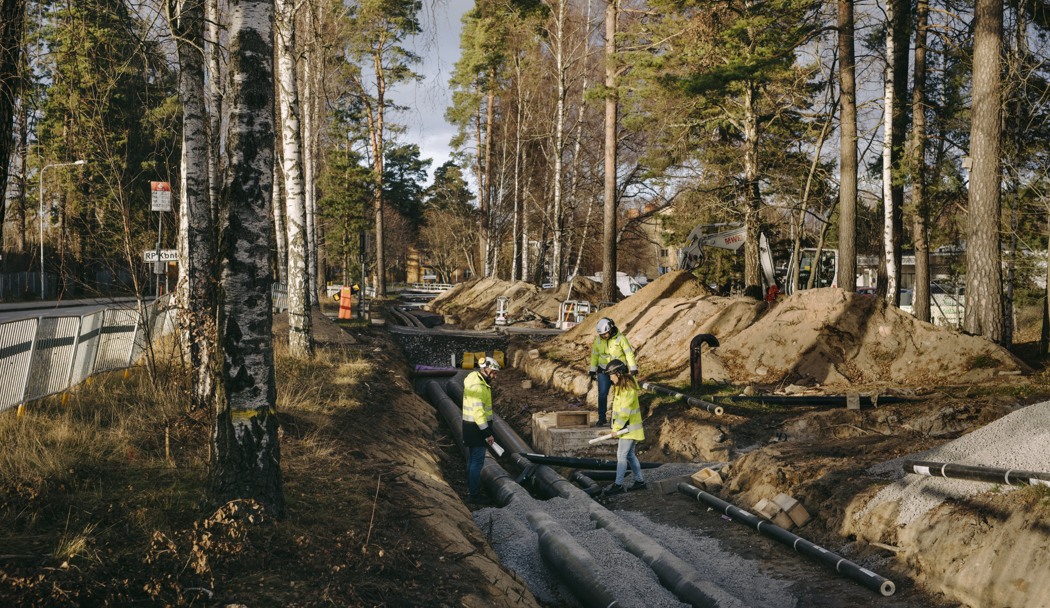 Personer i gula varselkläder inspekterar ledningsarbeten. 